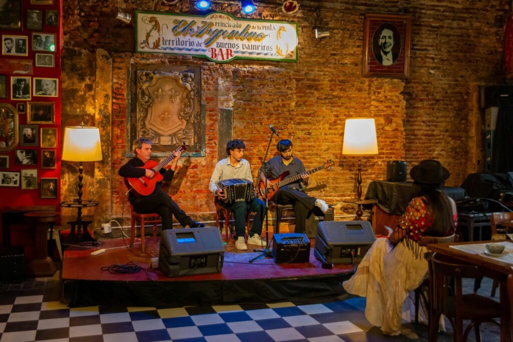 Three musicians performing live in a cozy Buenos Aires bar with guests enjoying the atmosphere.